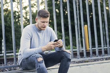 Obraz premium Junger Mann schreibt eine SMS