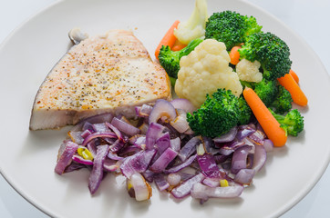 Sword-fish steak with vegetables on a plate