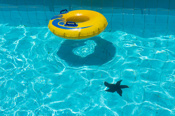 Swimming pool water with yellow floating ring