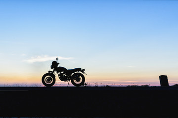 Silhouette of motorcycle with sunset background