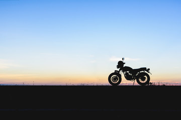 Fototapeta na wymiar Silhouette of motorcycle with sunset background