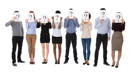 Obraz premium Group Of College Students Hiding Behind Question Mark Sign