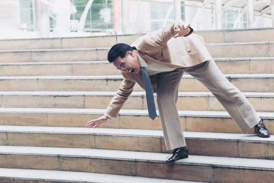 Businessman falling down the steps of staircase