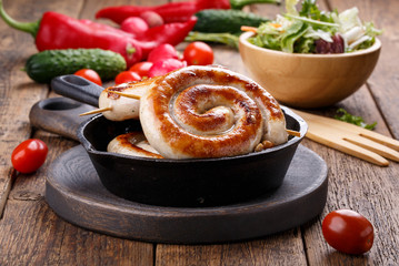 Spiral sausages in a small cast-iron frying pan