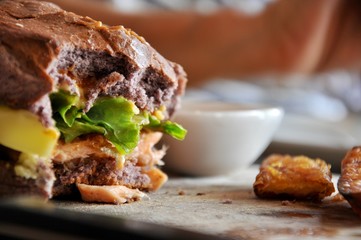 knife on hamburger and french fries on the wooden plate, focus at hamburger