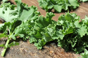 Fresh leaf of kale cabbage on wooden background. Green vegetable leaves. Top view . Healthy eating, vegetarian food