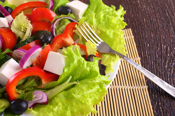 salad from fresh vegetables in a plate on a table, selective focus