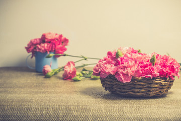 Beautiful bright pink carnation petals on Small basket. Vintge image style.