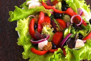 salad from fresh vegetables in a plate on a table, selective focus