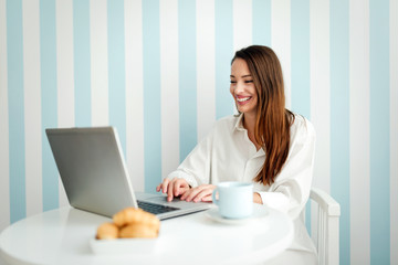 Young beautiful woman smiling and using laptop