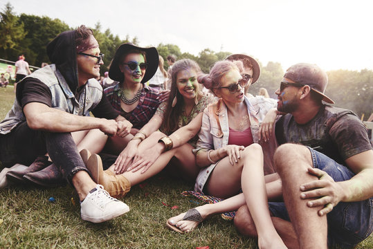 Friends sitting on the grass at music festival