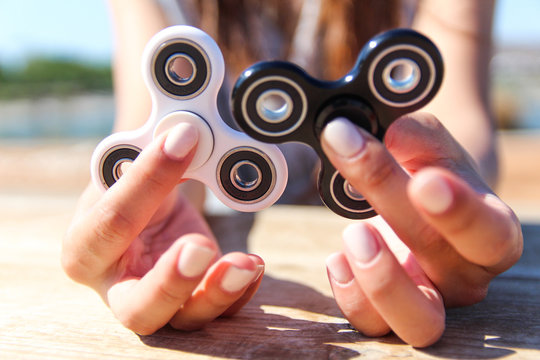 Women hand hold a white and black spinner