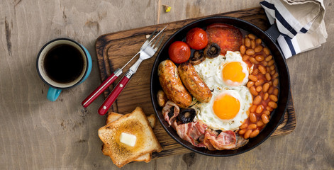 English breakfast on wooden table with copy space