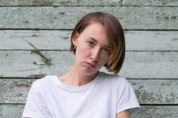 portrait of beautiful young angry woman in white t-shirt