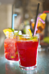 Alcohol bar, cocktail glass on the bar counter, cocktail glass in a bar. Drinking cocktails. Fresh drink cocktail on a color background.