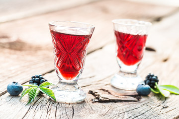 Sweet liqueur with alcohol and berry fruits in summer