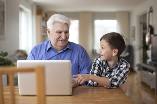Boy showing grandfather computer