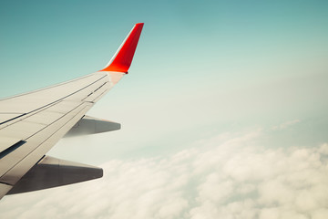 Fototapeta premium Cloudy sky with wing of airplane, vintage style background