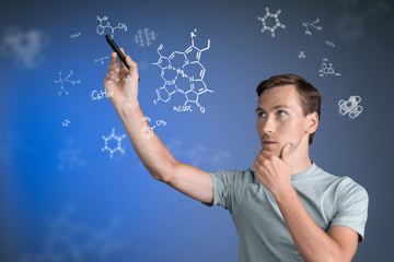 Man scientist with stylus or pen working with chemical formulas on blue background.