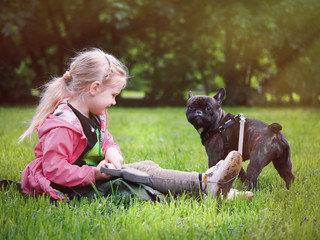 A child with a dog on a green lawn