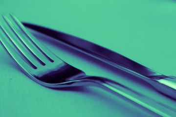 Elegant shiny fork and knife. Luxury restaurant cutlery set on the tablecloth.
