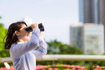young woman holding binocular glasses. business prospect concept.
