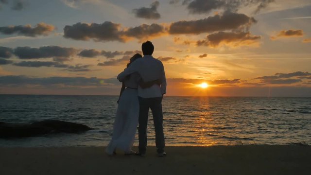 Young couple enjoys the sunset near the ocean