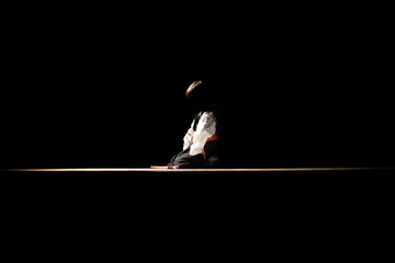 Silhouette of little samurai boy in the dark