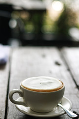 Cup of enery, Cappuccino coffee in white cup on wooden table