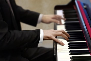 Fototapeta na wymiar Man in black suit playing piano
