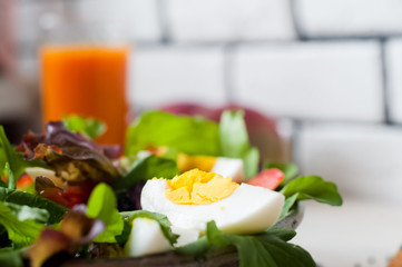 Fresh vegetable salad and freshly squeezed mango juice. Salad from arugula, black and red caviar, tomato, eggs, goat cheese, olive oil. Smoothies of mango, carrot, pumpkin. Vitamins, vegetarianism
