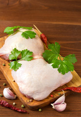 Raw chicken thighs on cutting board.