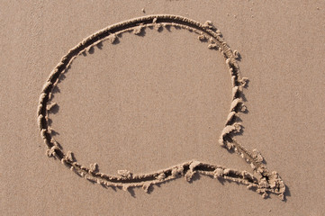 A speech or think bubble drawn out on a sandy beach. Beach background. Top view