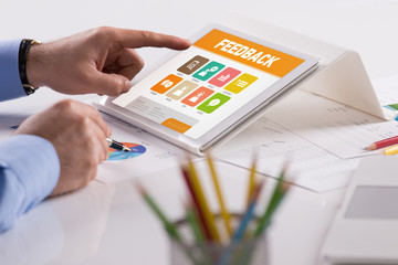Businessman working on tablet with Feedback on a screen