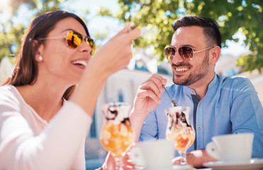 Dating in the cafe. Loving couple drinking coffee and eating fruit desserts. Dating, love, relationships
