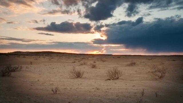 Clouds float over the desert at sunset. Timelapse
