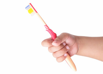 Child's hand holding a toothbrush, isolated on a white background