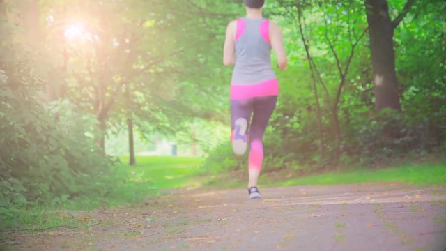 Runner woman running in park excercising outdoors. Slow motion