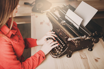 Young woman using typewriter, business concepts, retro picture style.