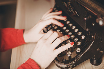 Secretary at old typewriter with telephone. Young woman using typewriter. Business concepts.