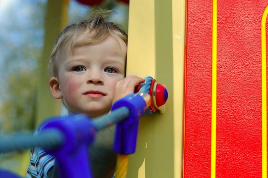 Little boy is hiding on the playground. Child concept