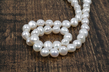 White pearls strand on the wooden background