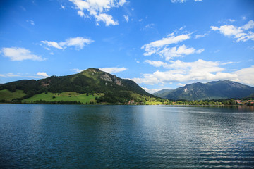 Idyllic mountain landscape in the Alps with lake, green meadows and mountains