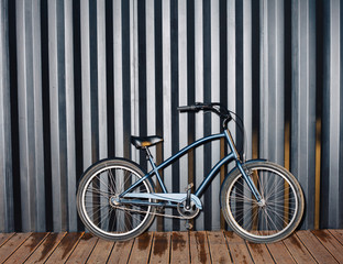 City night snapshot of a fashionable bicycle standing near a black sea container