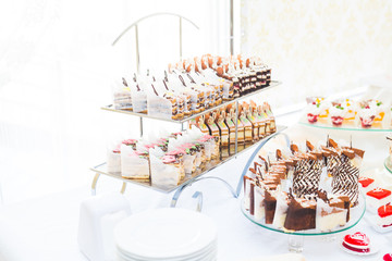 Delicious sweets on wedding candy buffet with desserts, cupcakes
