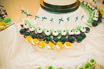 Fototapeta premium Delicious sweets on wedding candy buffet with desserts, cupcakes