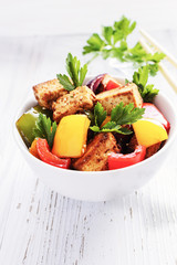 Tofu salad with pepperoni on white wooden background.