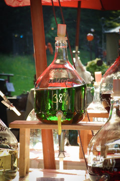 Likör in Korbflasche, grün, Alkohol auf Markt