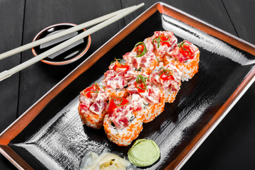 Sushi Roll - Maki Sushi with red caviar, Crab meat, avocado, cucumber and cream cheese on dark wooden background. Top view. Japanese cuisine
