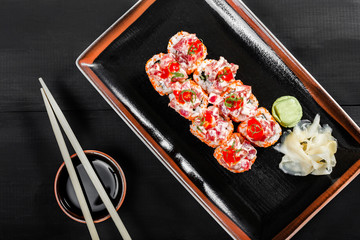 Sushi Roll - Maki Sushi with red caviar, Crab meat, avocado, cucumber and cream cheese on dark wooden background. Top view. Japanese cuisine